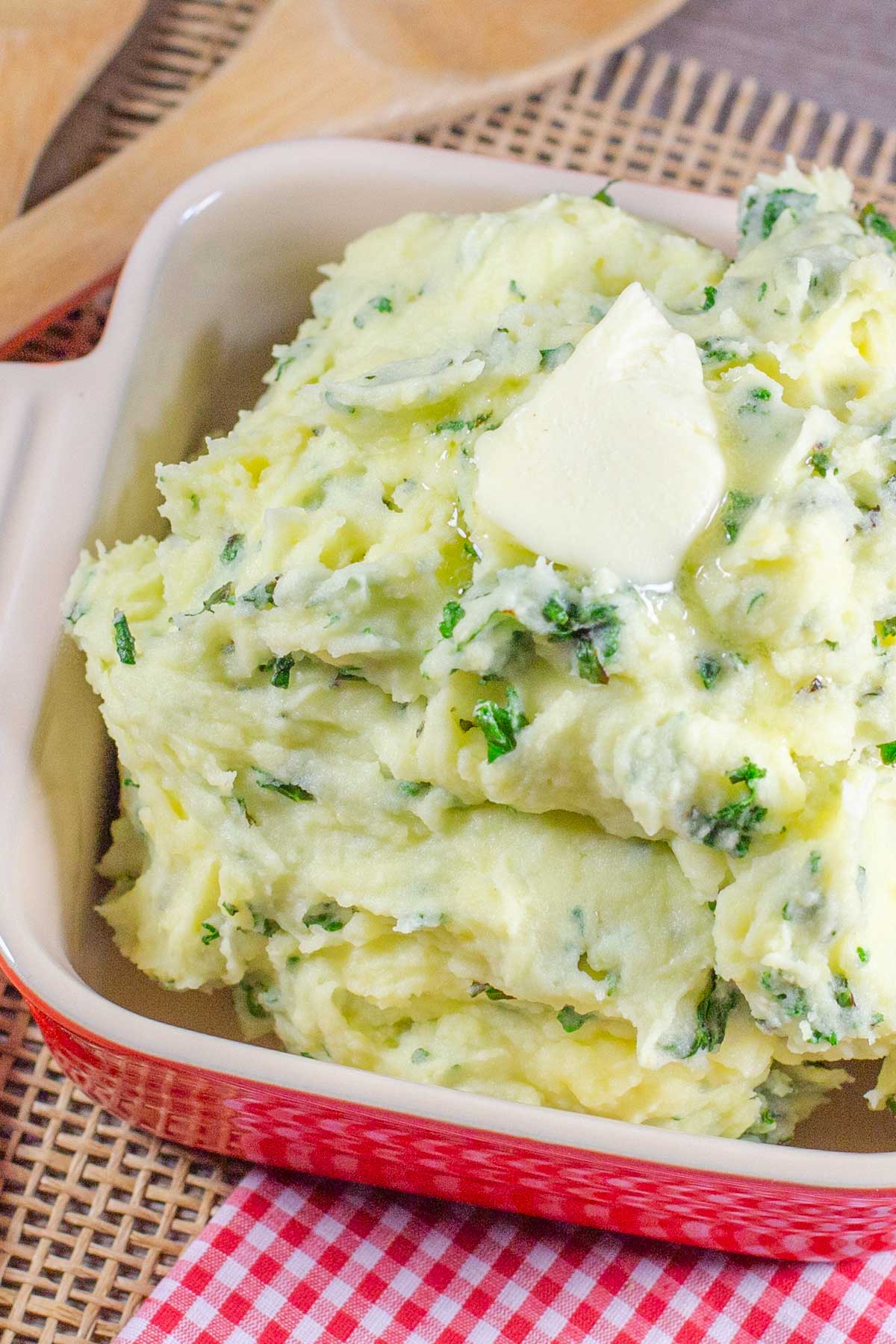 Mashed potatoes with kale topped with pat of butter.