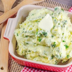 Mashed potatoes with kale topped with pat of butter.