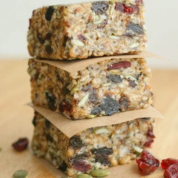 Three protein bars stacked separated by square of brown parchment paper.