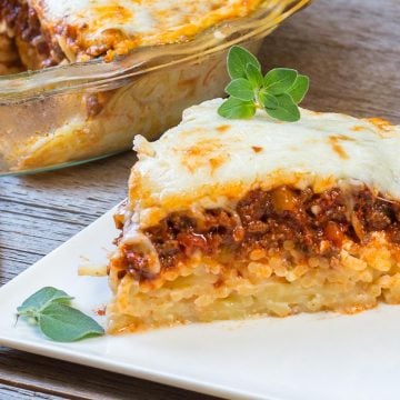 Slice of pie with layers of spaghetti, meat sauce and cheese.