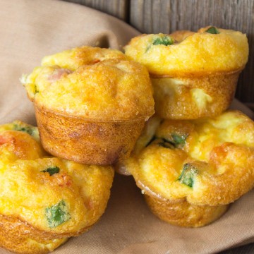 Four mini sized egg bites stacked together on tan napkin.