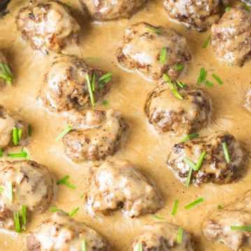 Cast iron skillet filled with meatballs in a creamy sauce.