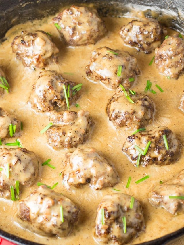 Cast iron skillet filled with meatballs in a creamy sauce.