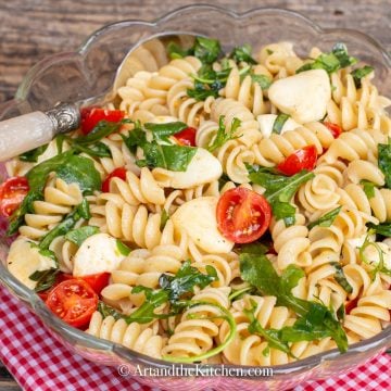 Rotini pasta tossed together with bocconcini, garden fresh cherry tomatoes, arugula, and fresh basil.