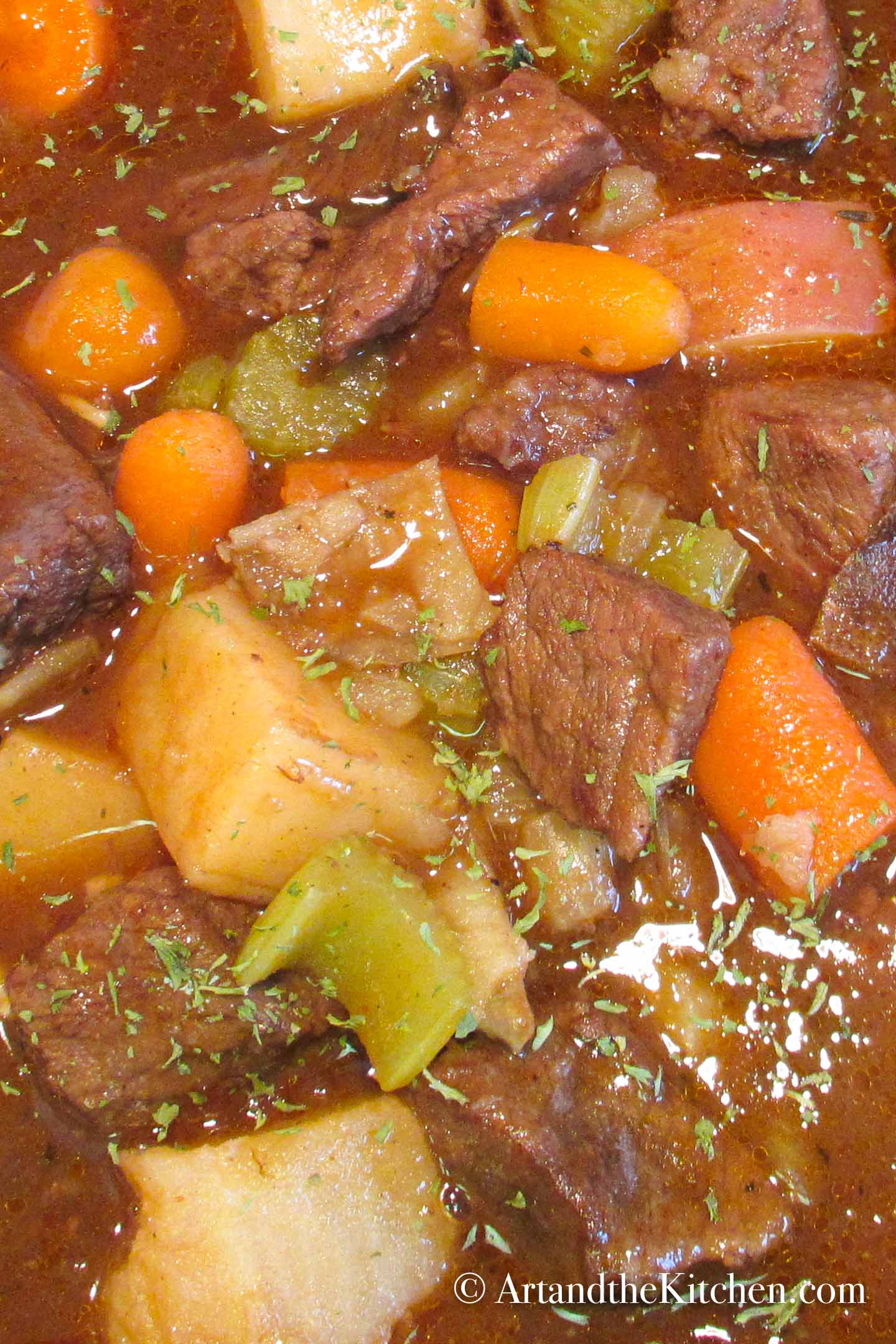 Pot of beef stew with potatoes, carrots and vegetables in rich gravy.