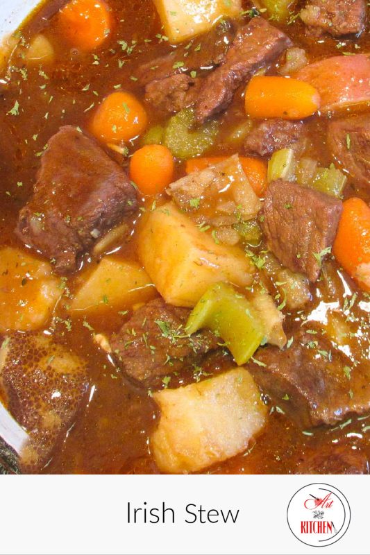 Pot of stew with beef, carrots, potatoes in saucy gravy.