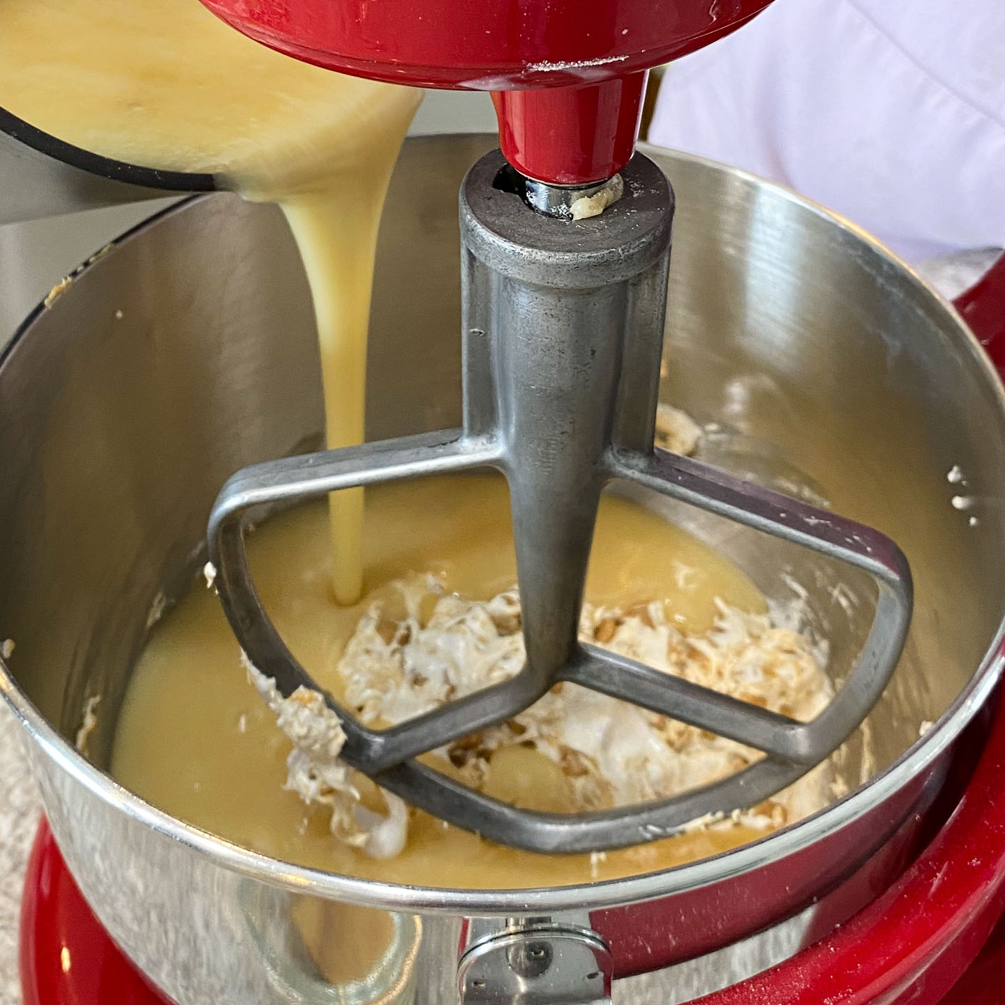 Hot butter sugar sauce poured over marshmallow peanut butter mix in standing mixer.