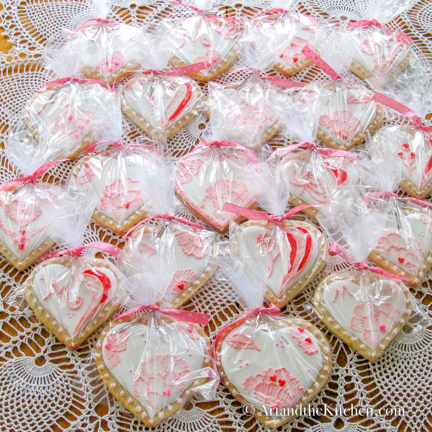 Heart shaped sugar cookies package in cellophane bags tied with pink ribbon.