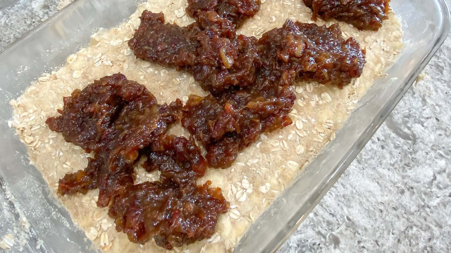 Dollops of cooked dates on top of oat crumb crust.