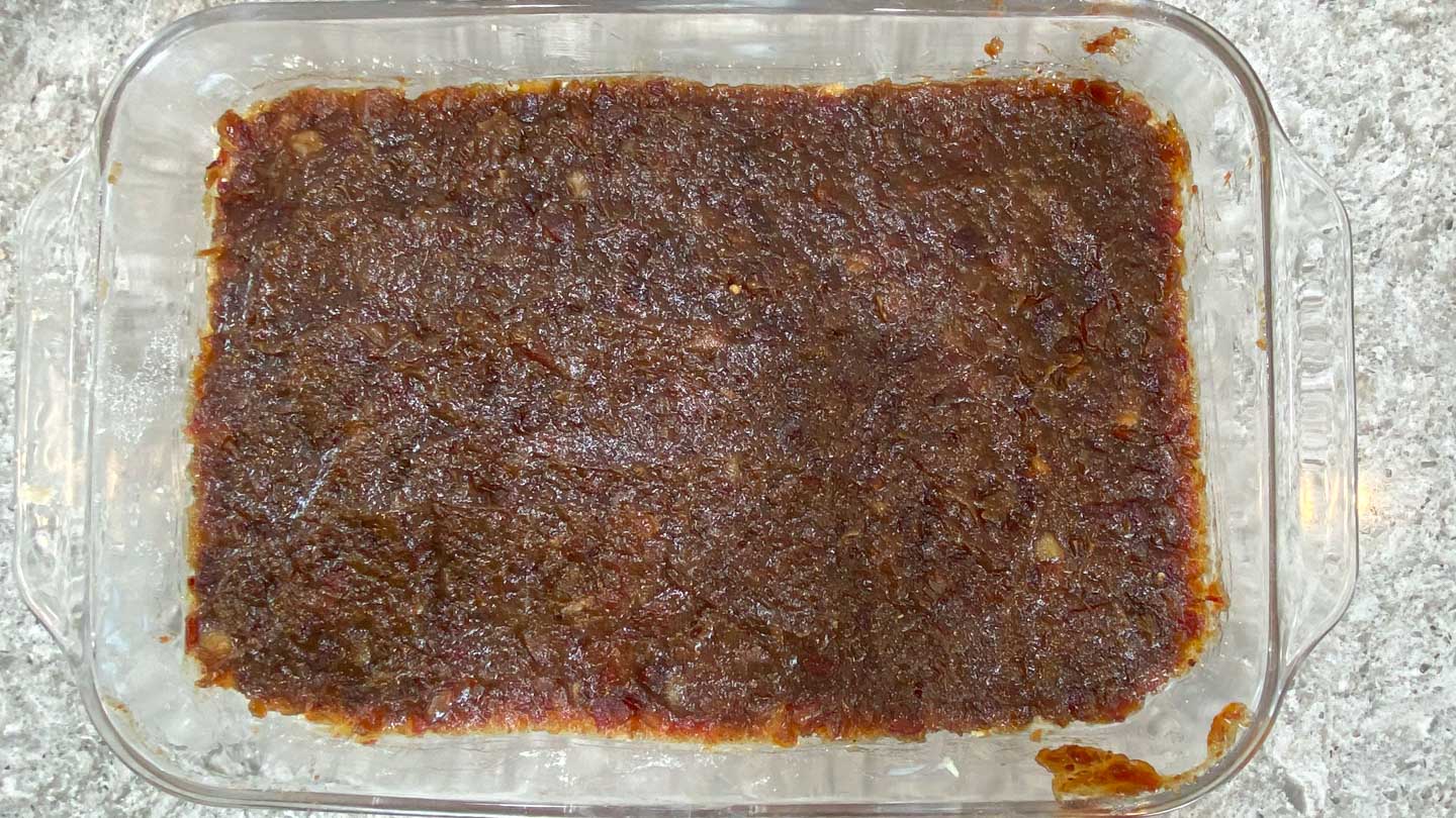 Cooked date mixture spread on crumb crust in glass baking pan.