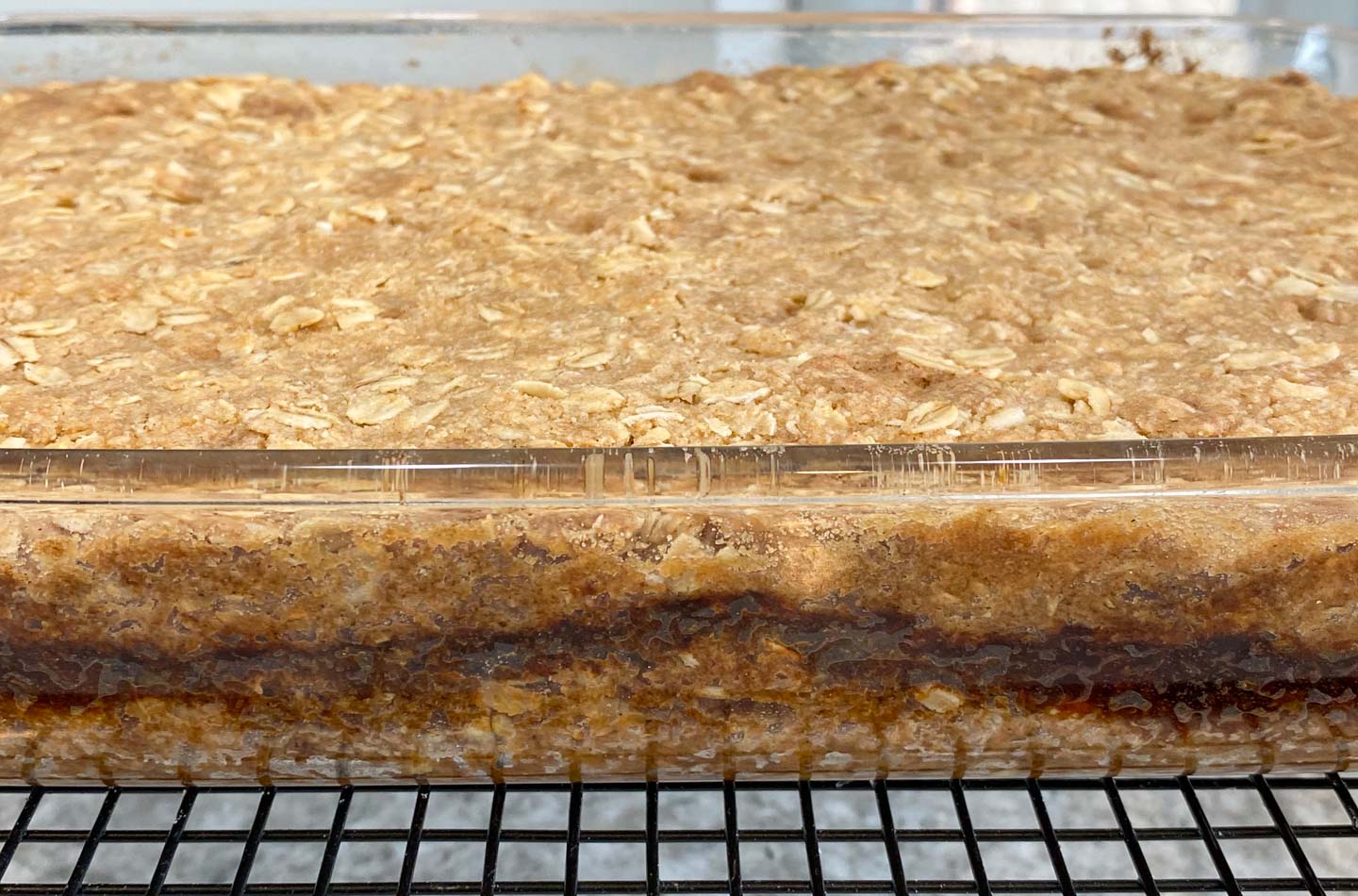 Golden brown baked date squares in glass baking pan.