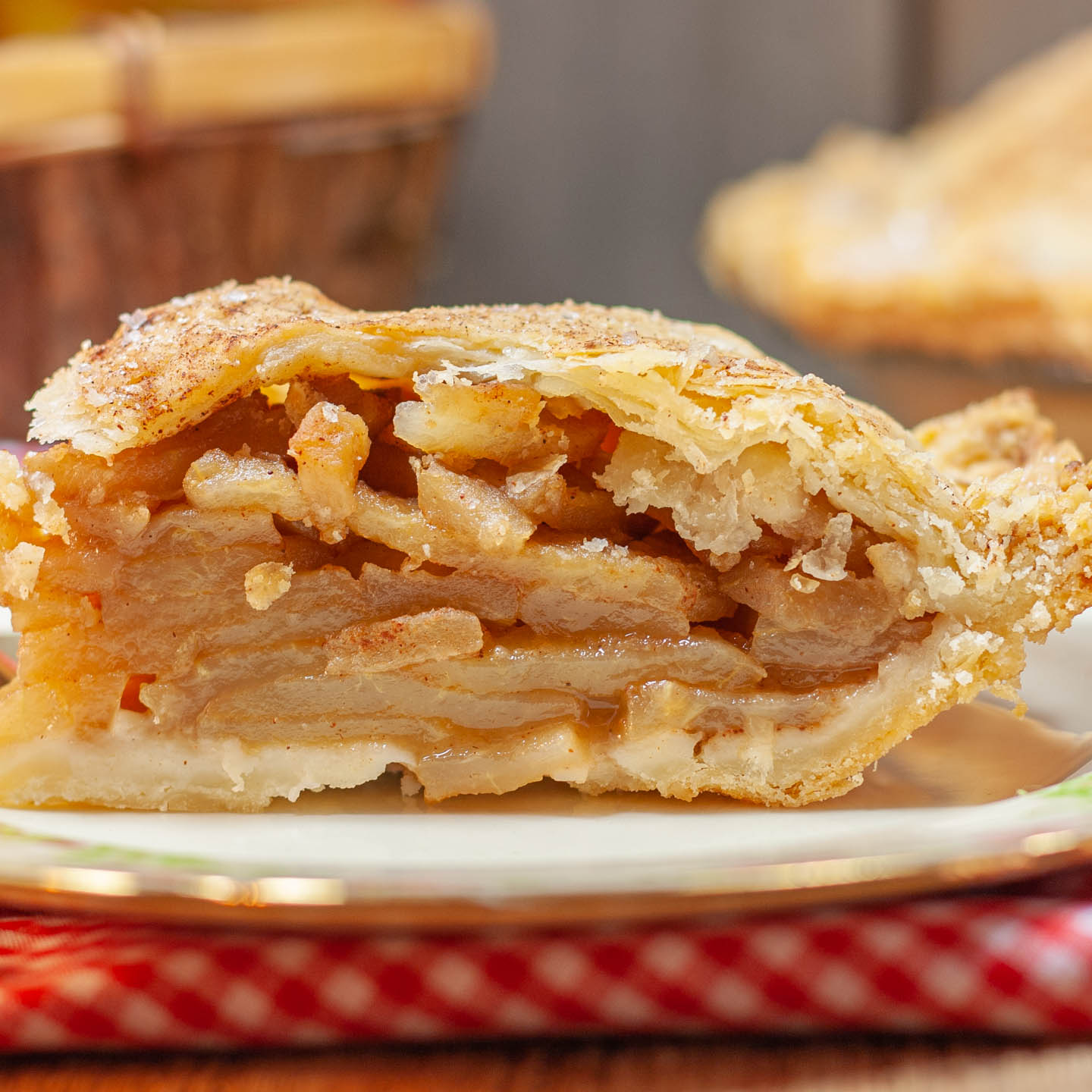 slice of apple pie on decorative plate.