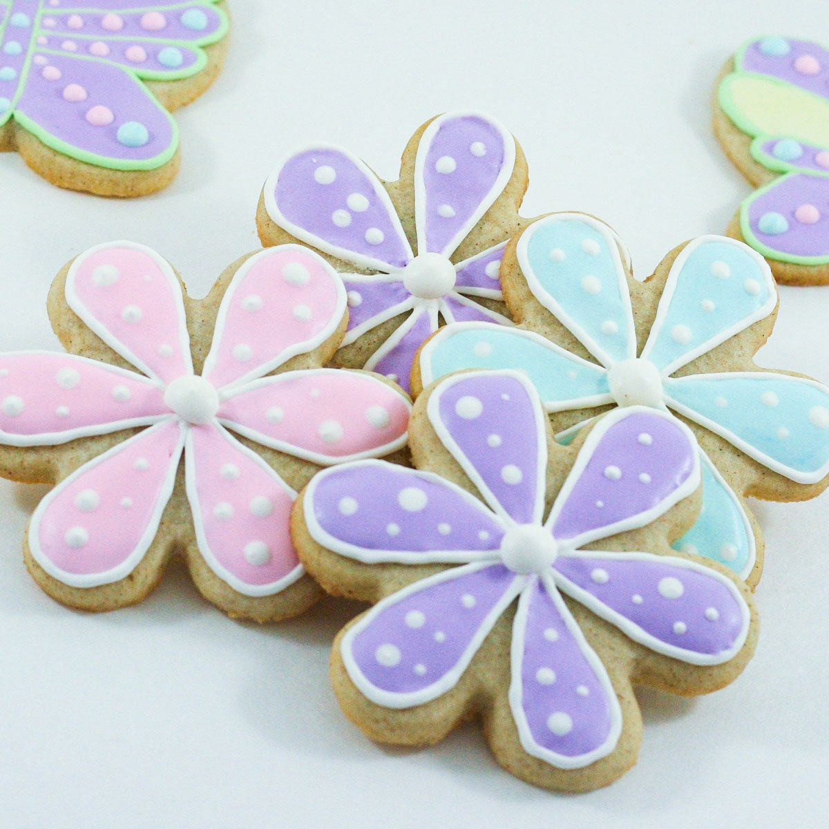 Flower and butterfly shaped sugar cookies decorated with colourful royal icing.