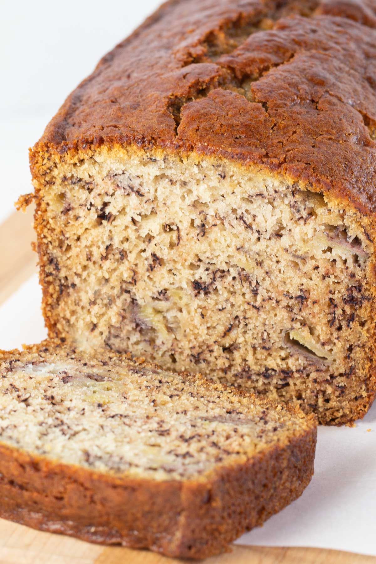 Whole loaf of banana bread with one slice cut.