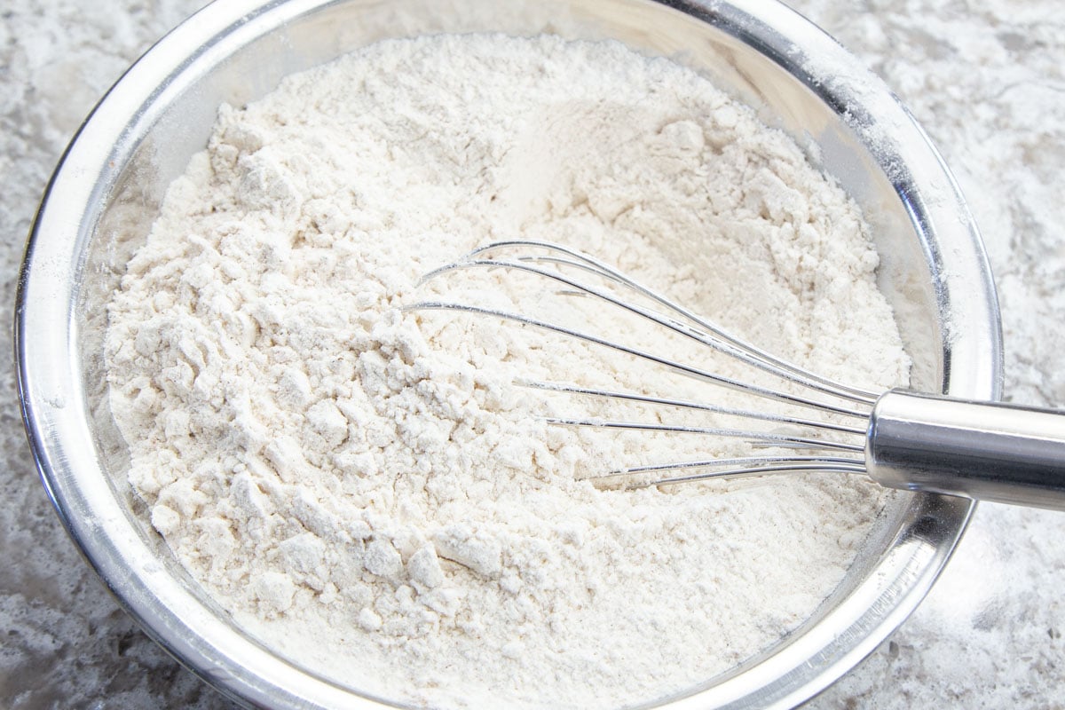 Flour and spices whisked together in stainless steel bowl.