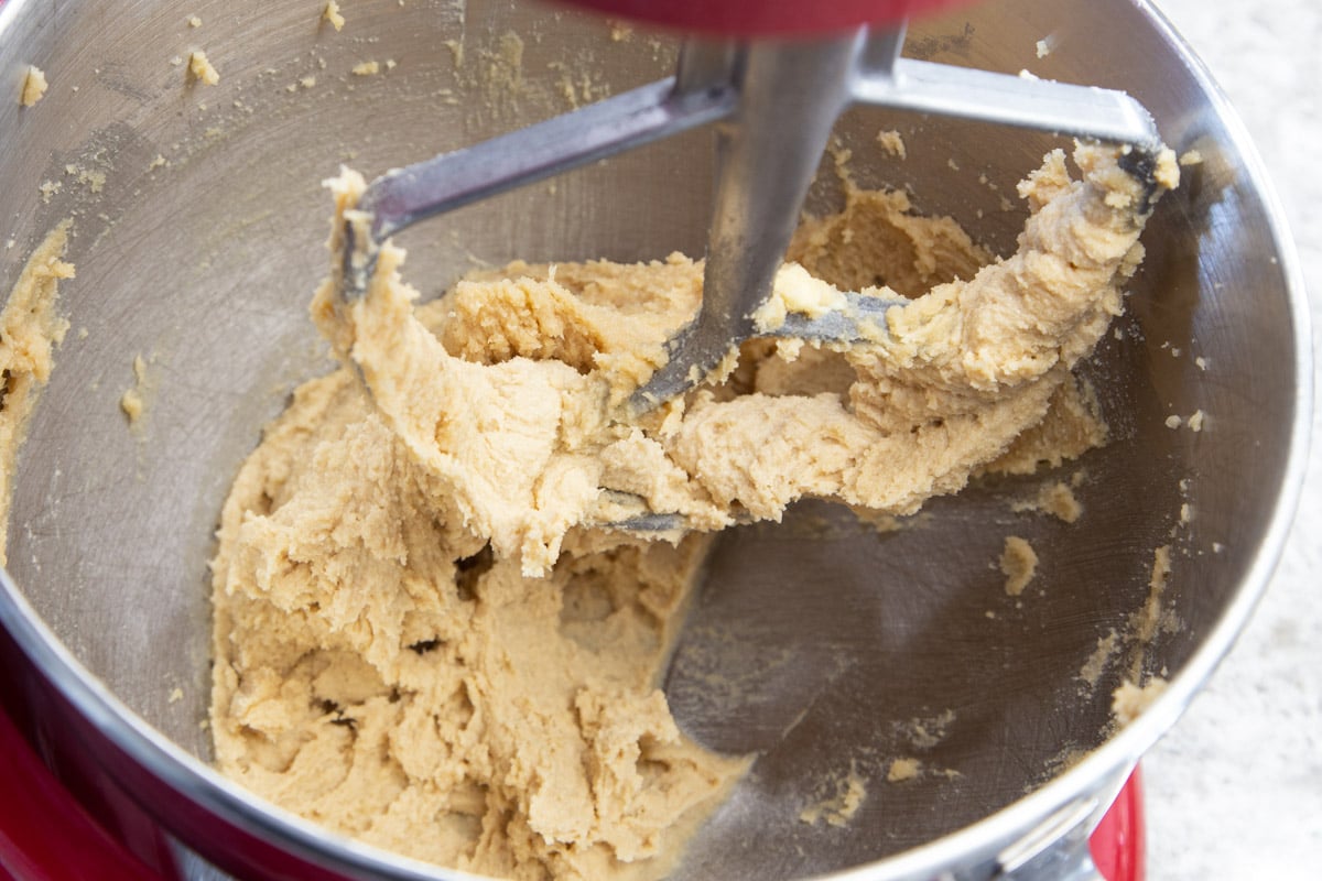 Butter and brown sugar mixture in stainless steel mixing bowl with paddle attachment.