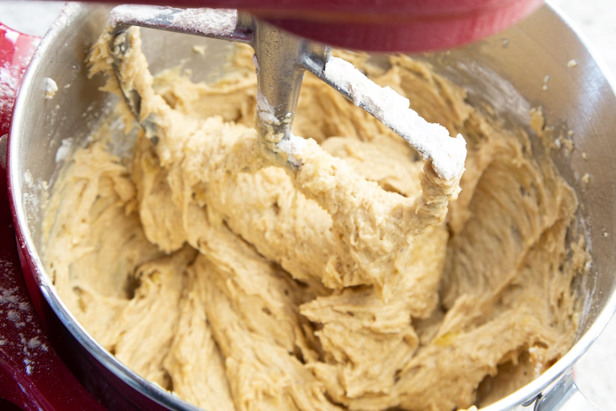 Cookie dough in stainless steel mixing bowl with paddle attachment.