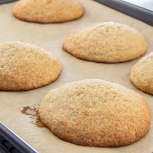 Fluffy banana cookies on brown parchment lined baking sheet.