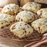 Cinnamon and raisin scones on a copper cooling rack.