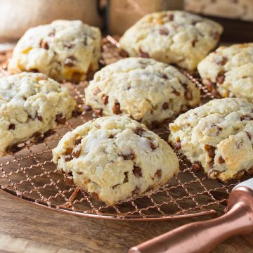 Cinnamon and raisin scones on a copper cooling rack.