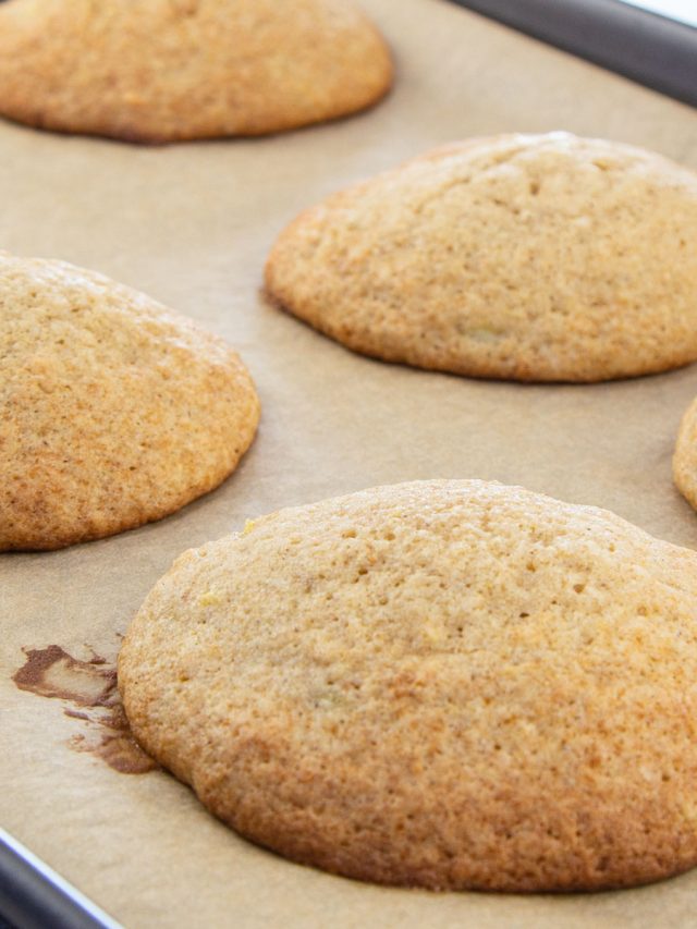 Fluffy banana cookies on brown parchment lined baking sheet.