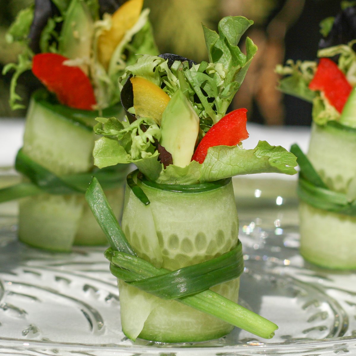 Thin sliced cucumber rolled, tied with green onion and stuffed with salad greens and avocado.