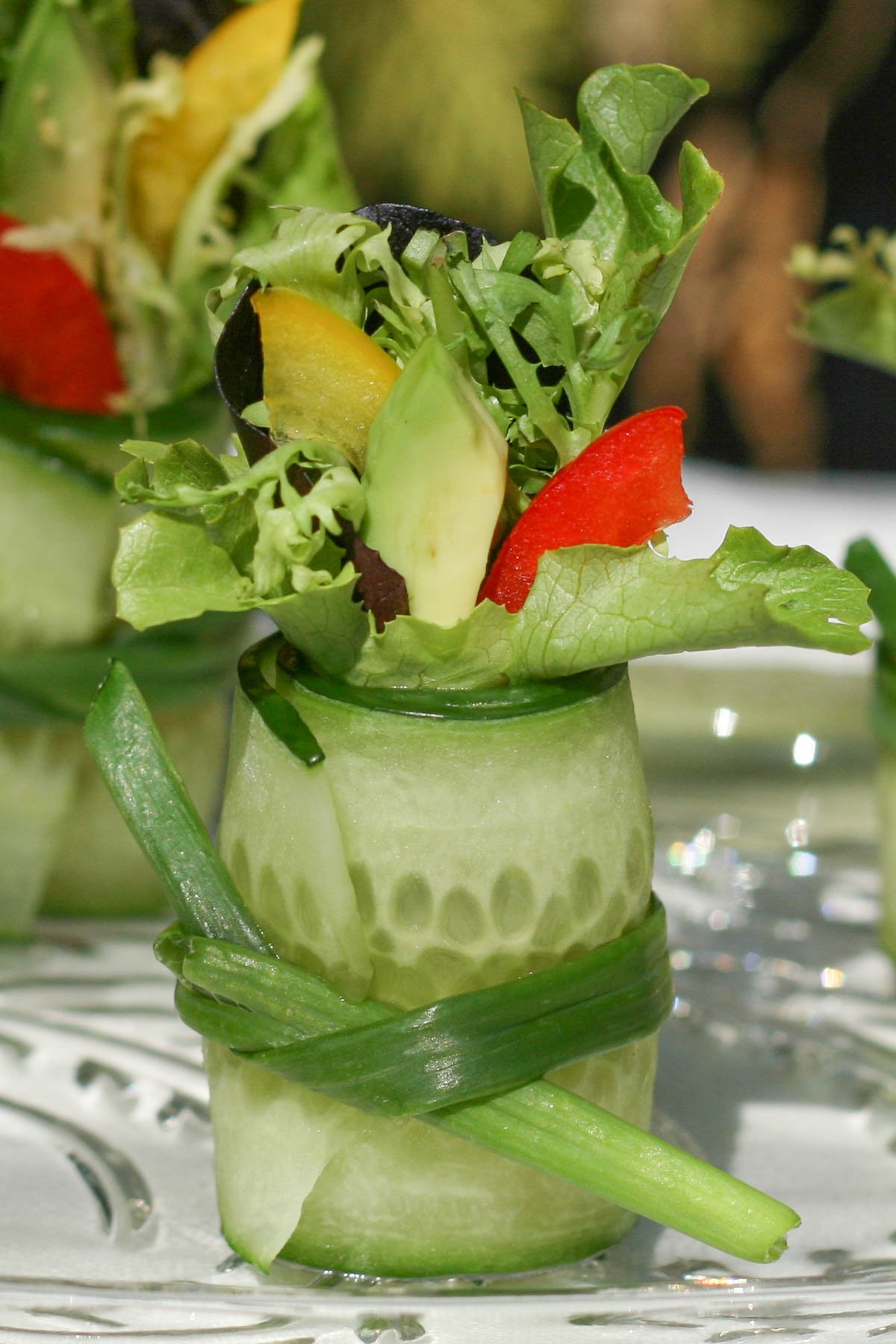 Thin sliced cucumber rolled, tied with green onion and stuffed with salad greens and avocado.