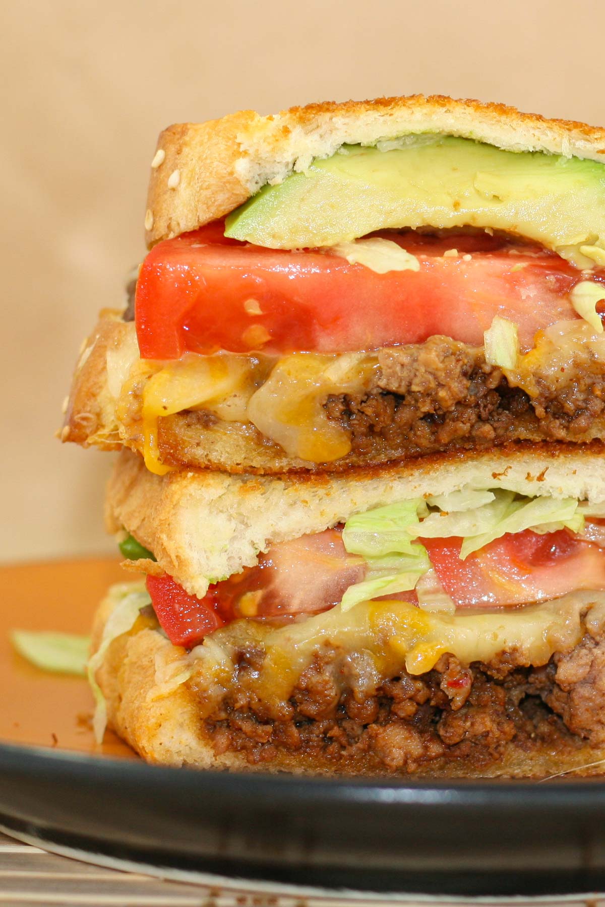 Grilled cheese sandwich with layers of taco flavored beef, tomatoes, lettuce and avocado.
