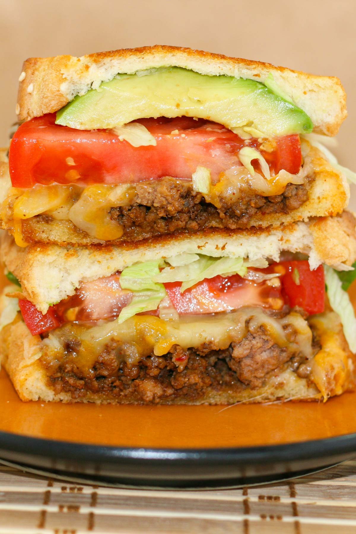 Grilled cheese sandwich with layers of taco flavored beef, tomatoes, lettuce and avocado.