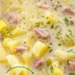 Creamy soup of potatoes and ham in a blue bowl.