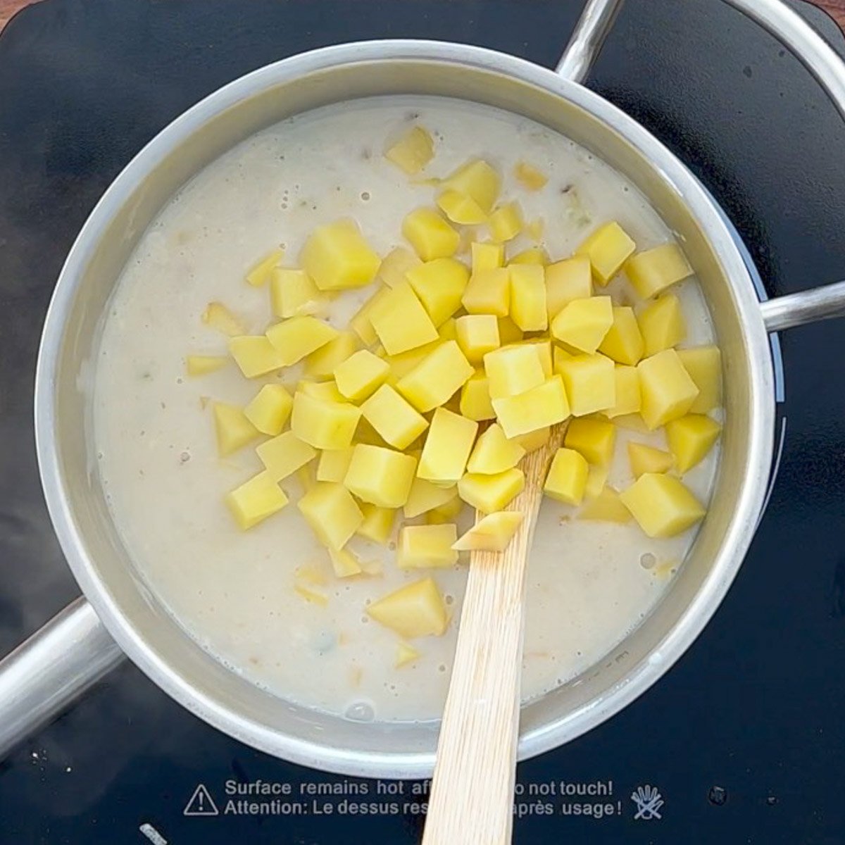 Cubed potatoes stirred into creamy white broth.