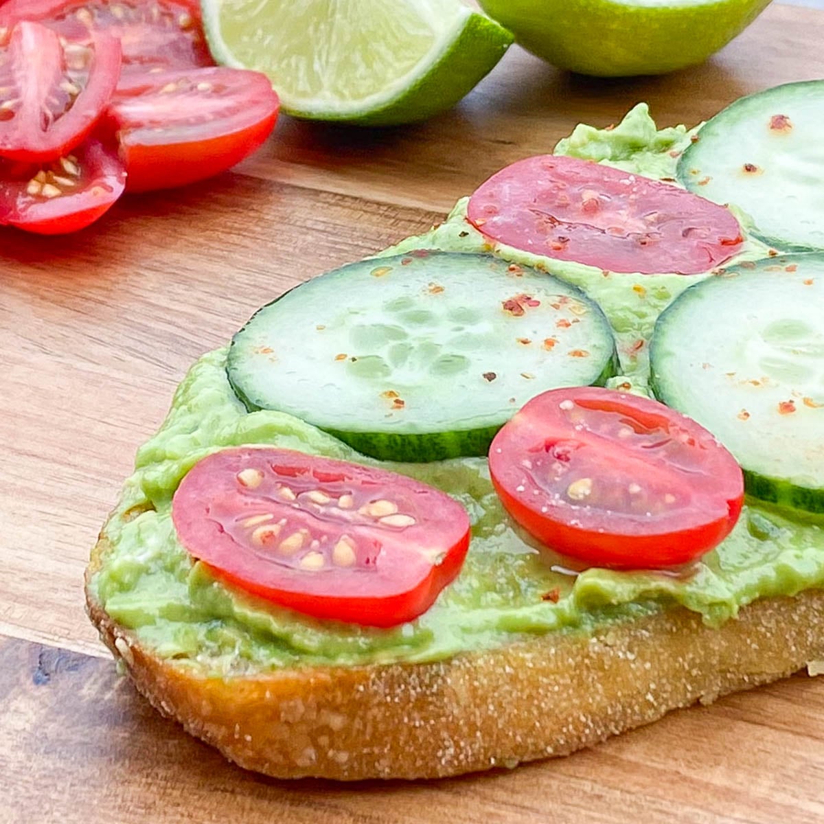 Crusty bun topped with mashed avocado, cherry tomato and cucumber slices.