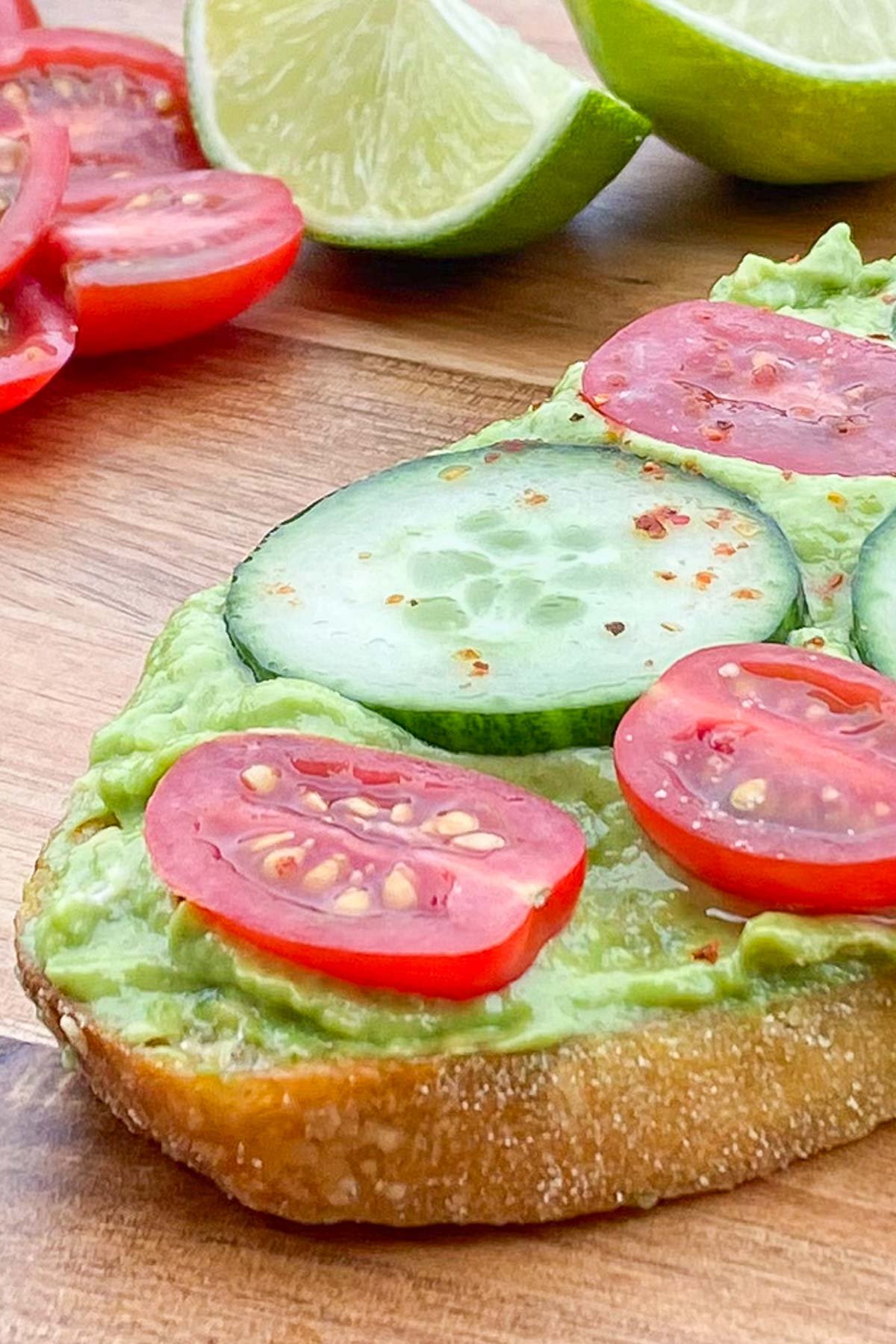 Crusty bun topped with mashed avocado, cherry tomato and cucumber slices.