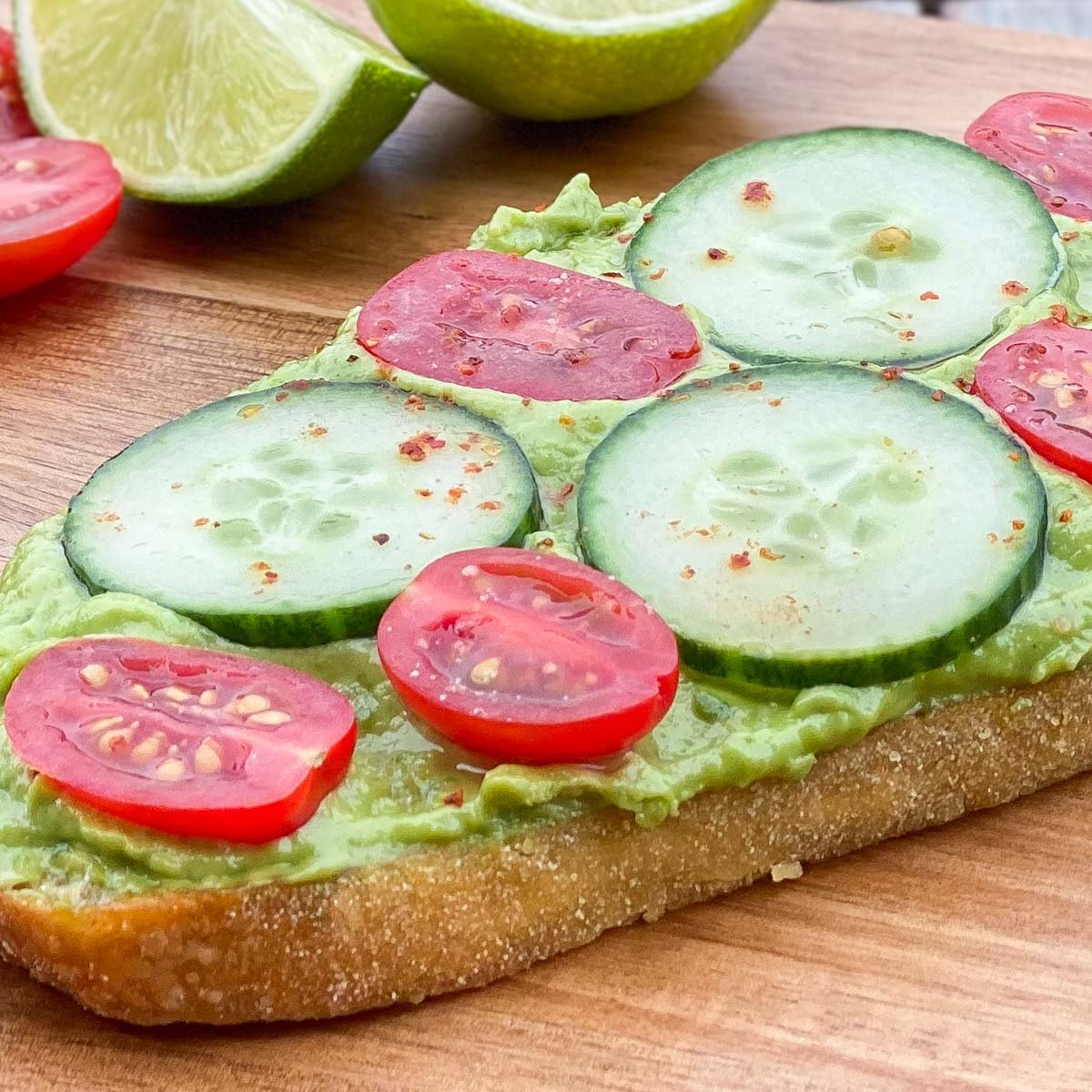 Crusty bun topped with mashed avocado, cherry tomato and cucumber slices.