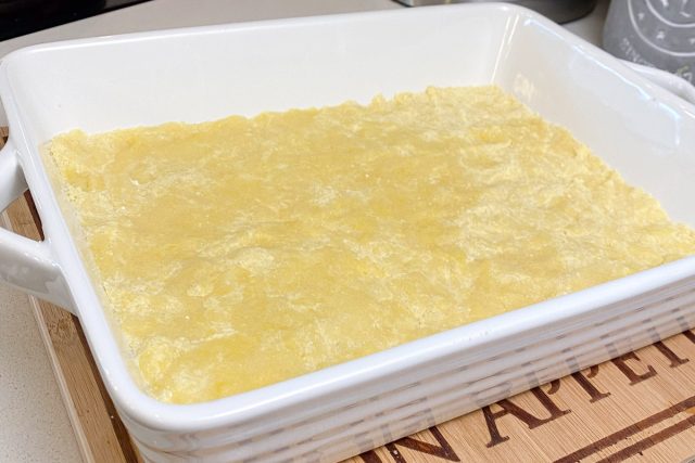 Lemon crust pressed into white cake pan.