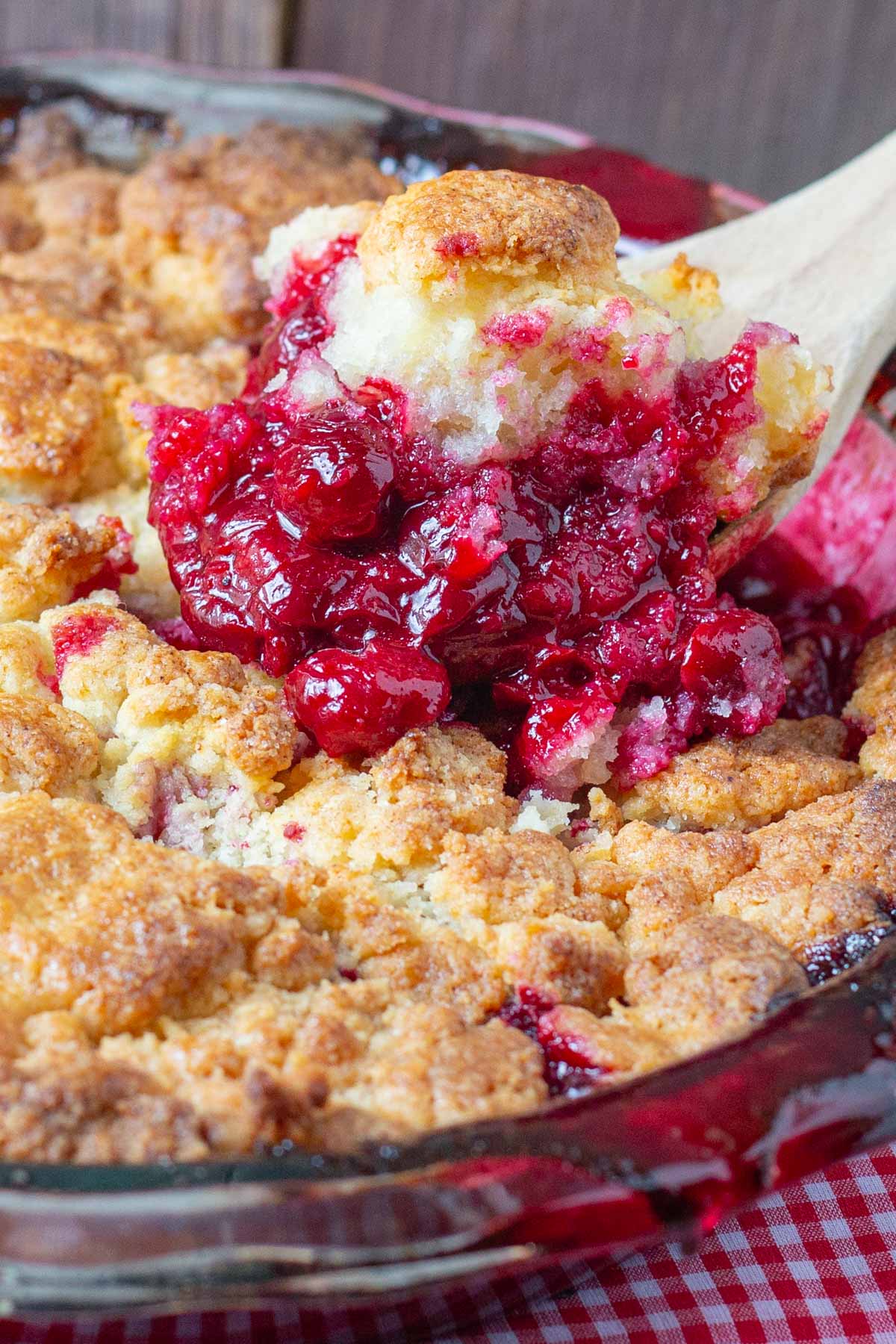 Cherry filling with biscuit cobbler topping in glass pie plate.