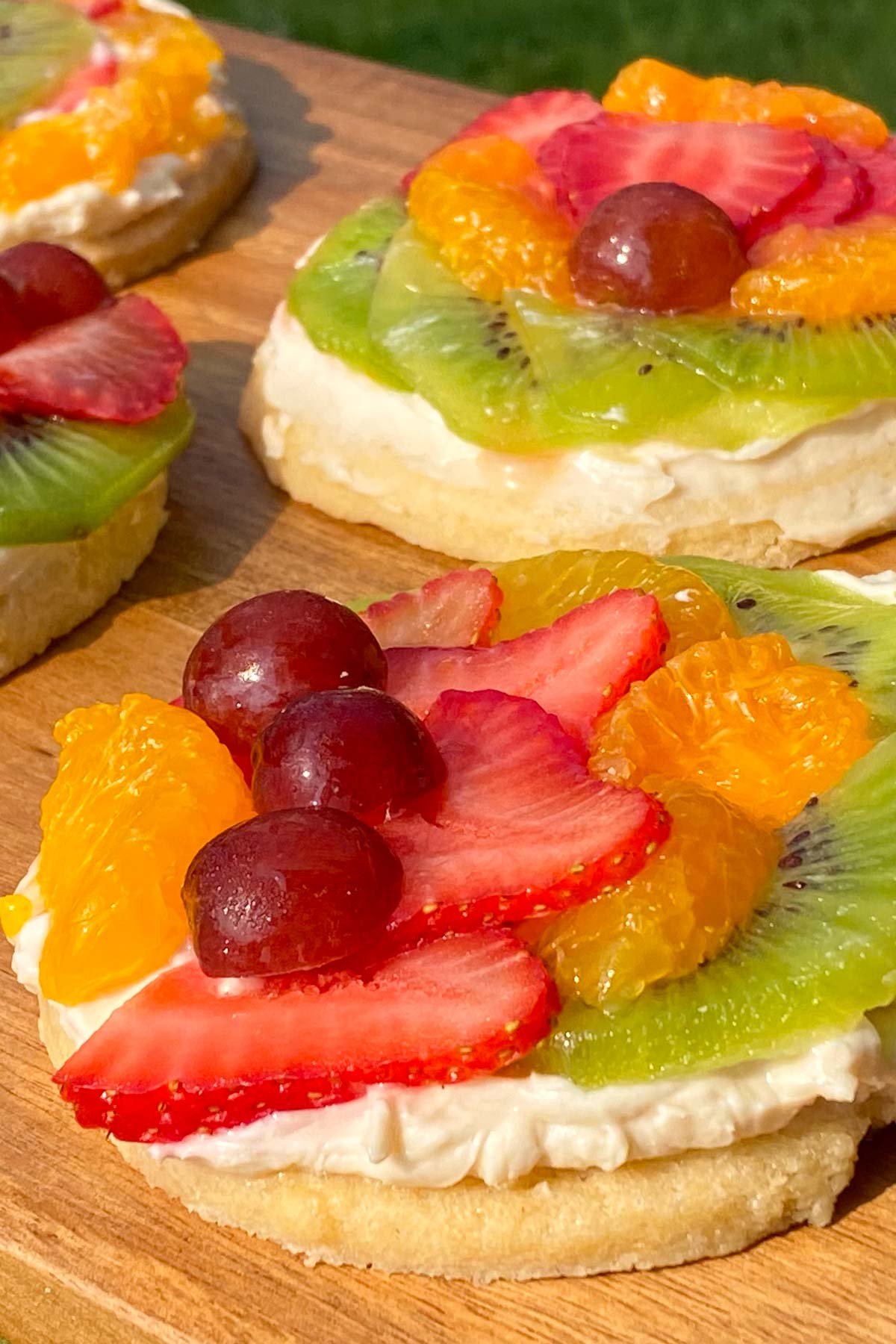 Sugar cookies topped with cream cheese and fresh fruit.