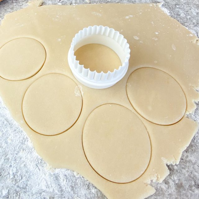 Sugar cookie dough cut with circle cookie cutter.