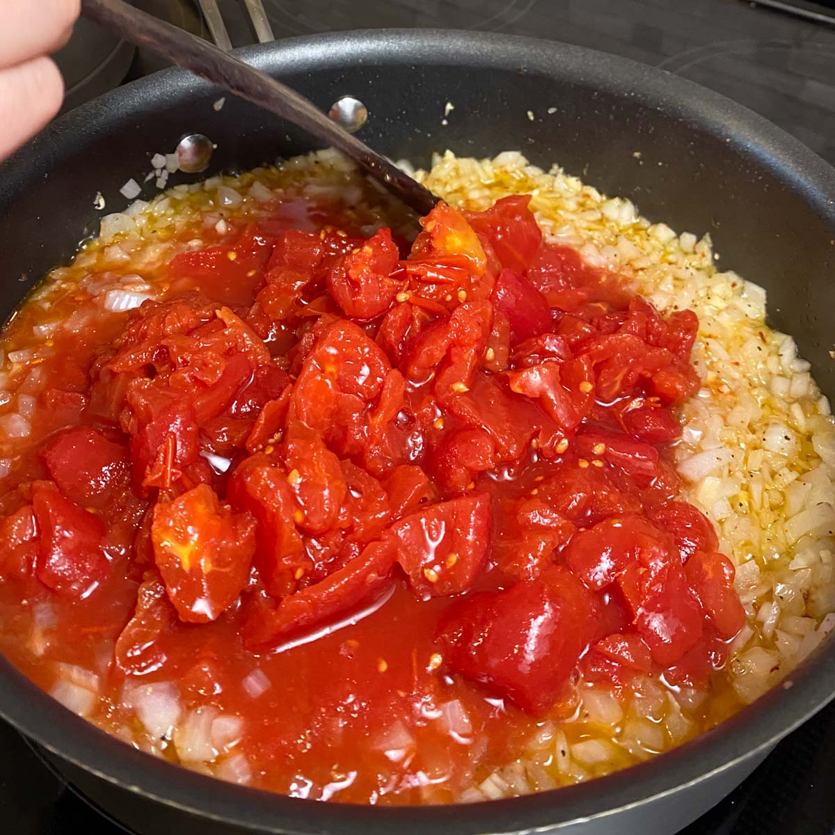 Skillet of sautéed onions and chopped tomatoes.