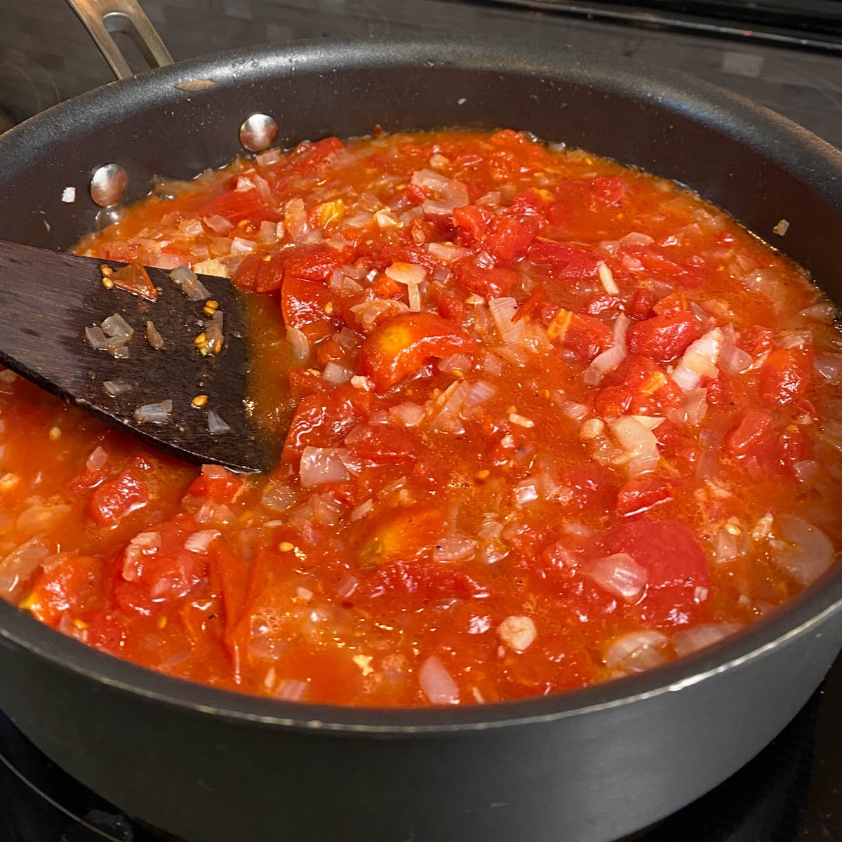 Skillet of tomato, onion vodka sauce simmering.