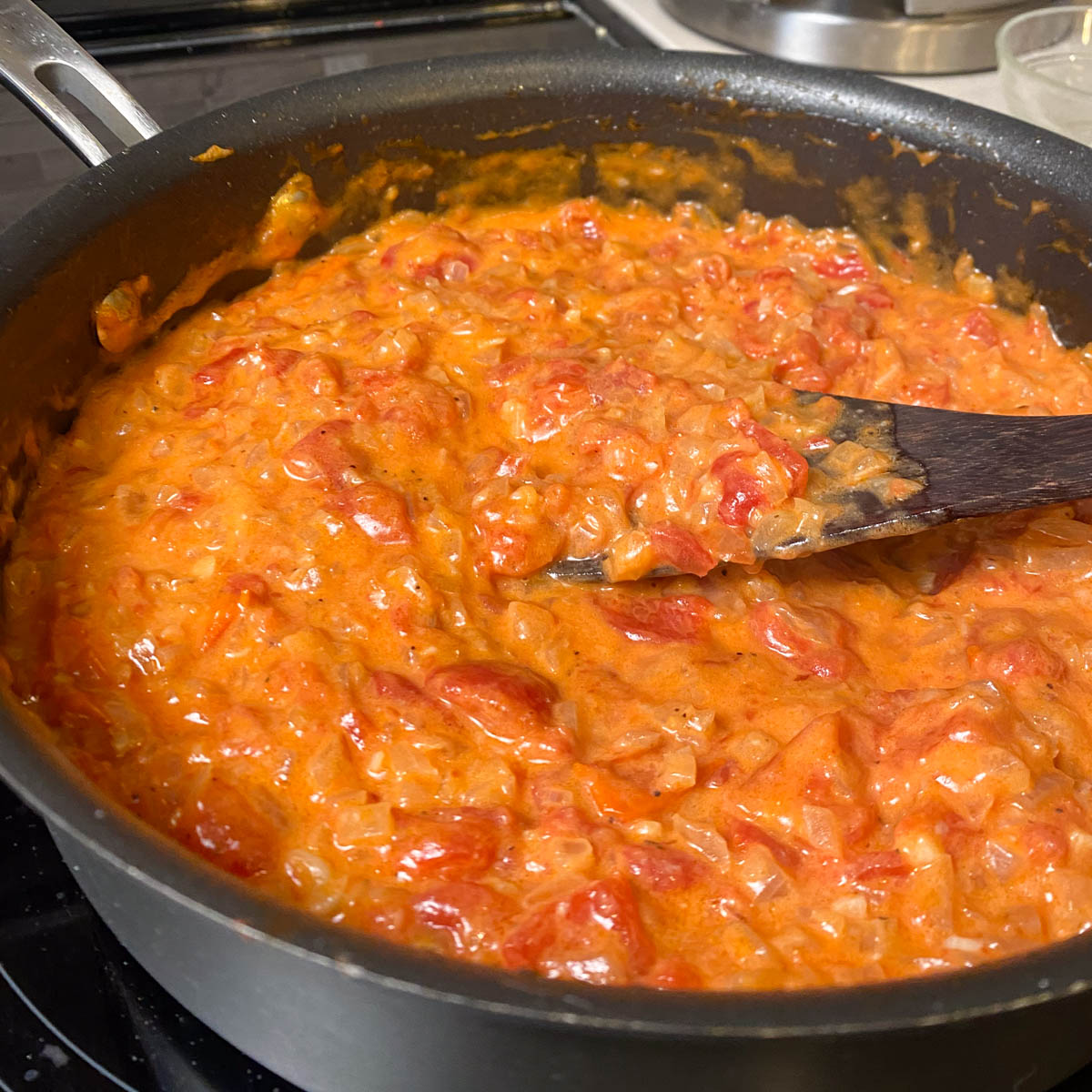 Skillet of creamy tomato sauce simmering.