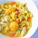 Bowl of soup with chicken, cauliflower, carrots and broad noodles.