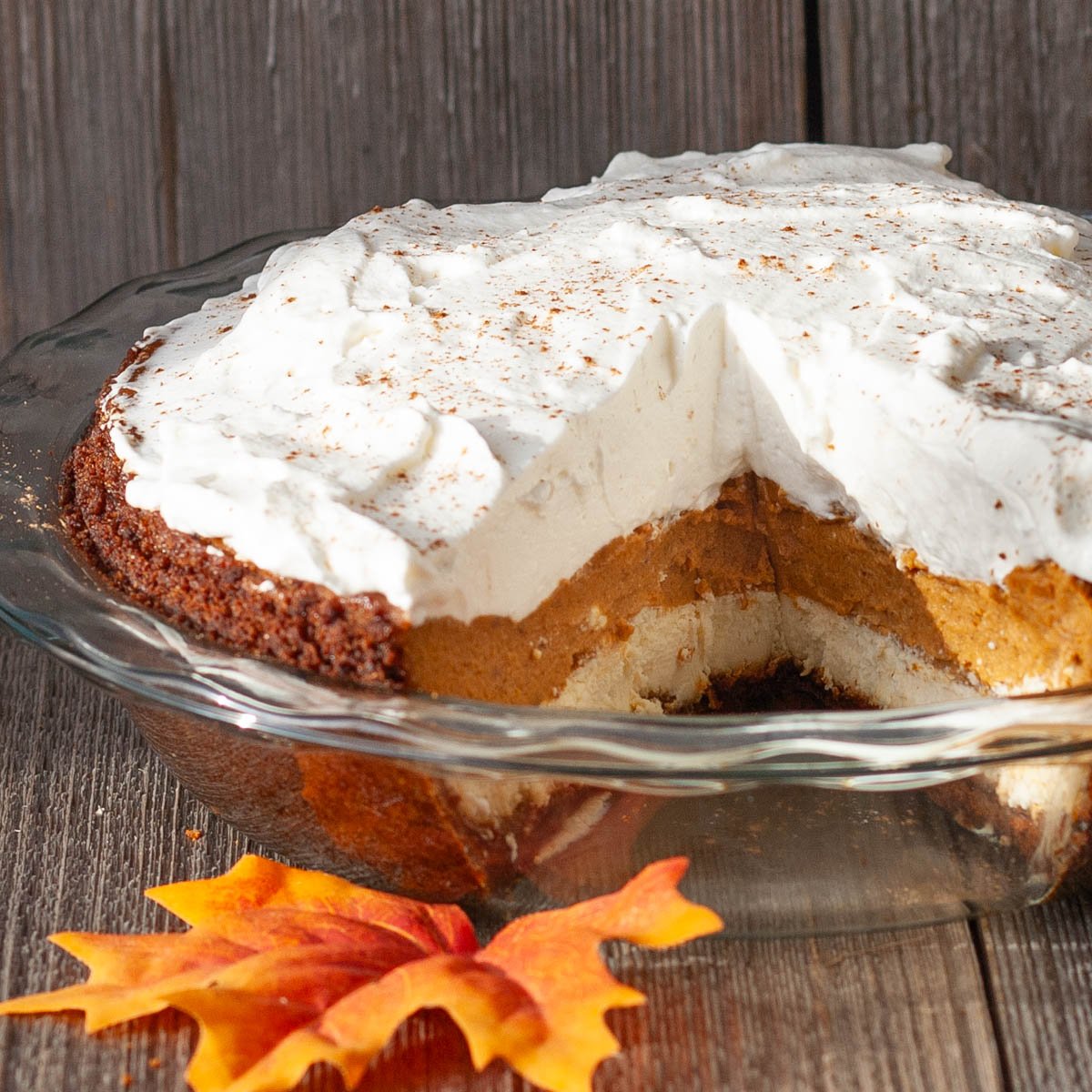 Cream cheese and pumpkin layered pie topped with whipped cream.