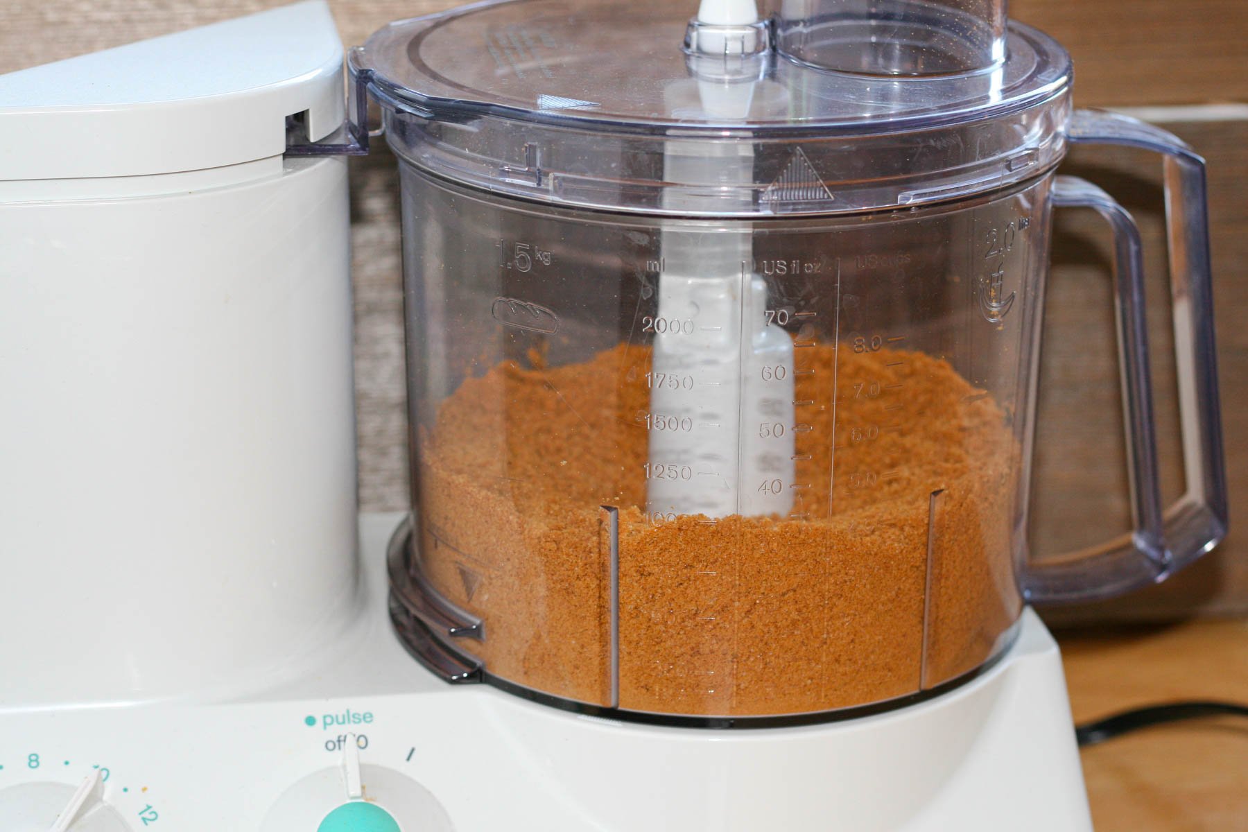 Food processor filled with ground up ginger cookies.