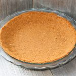 Pie crust made with gingersnaps in a glass pie plate.