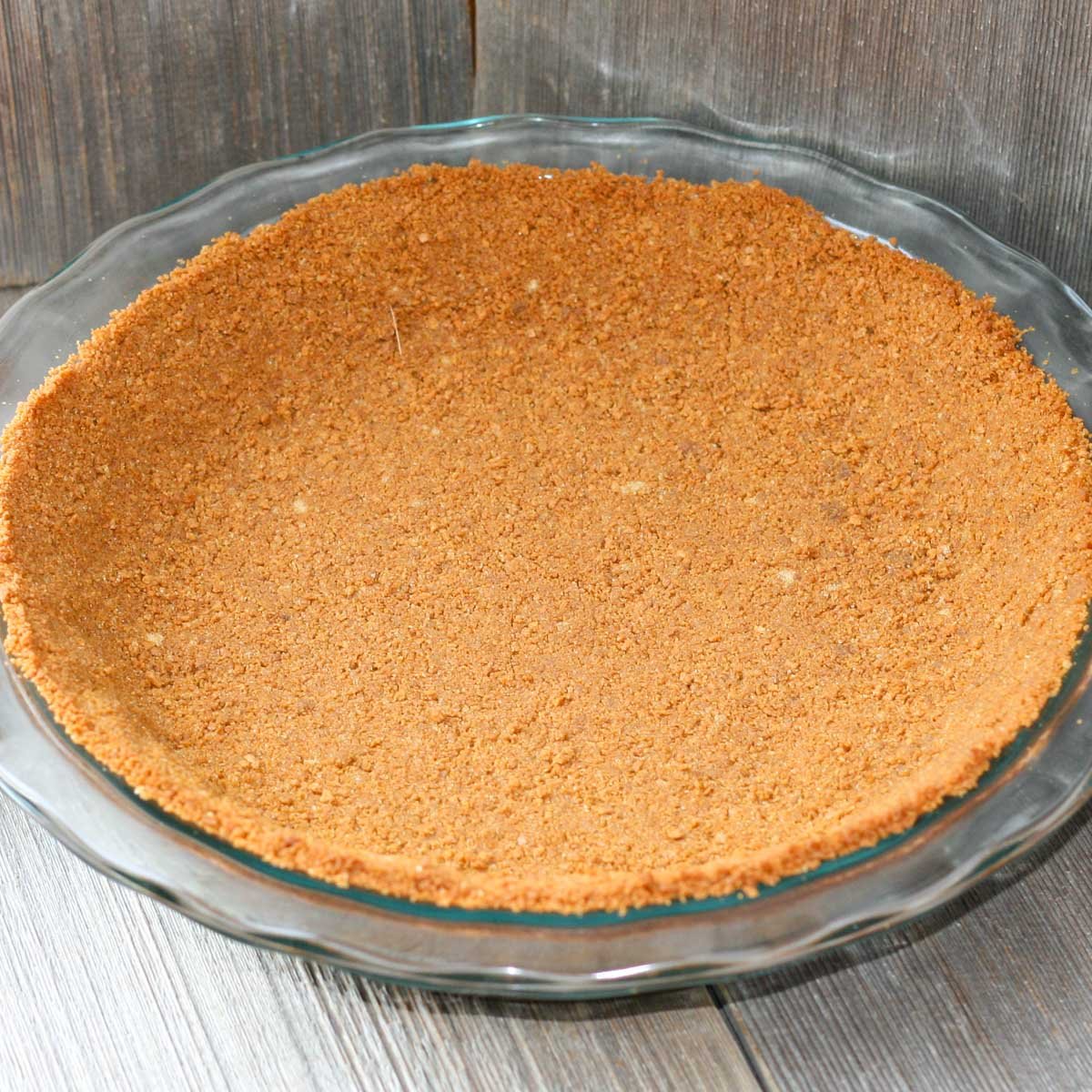 Pie crust made with gingersnaps in a glass pie plate.