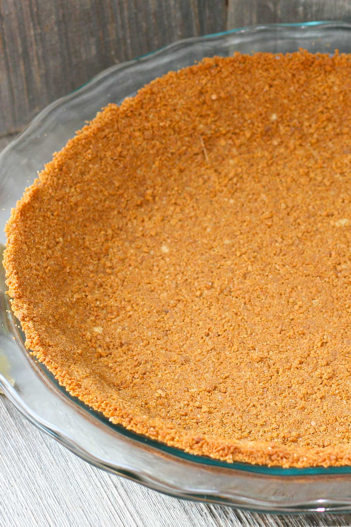 Pie crust made with gingersnaps in a glass pie plate.