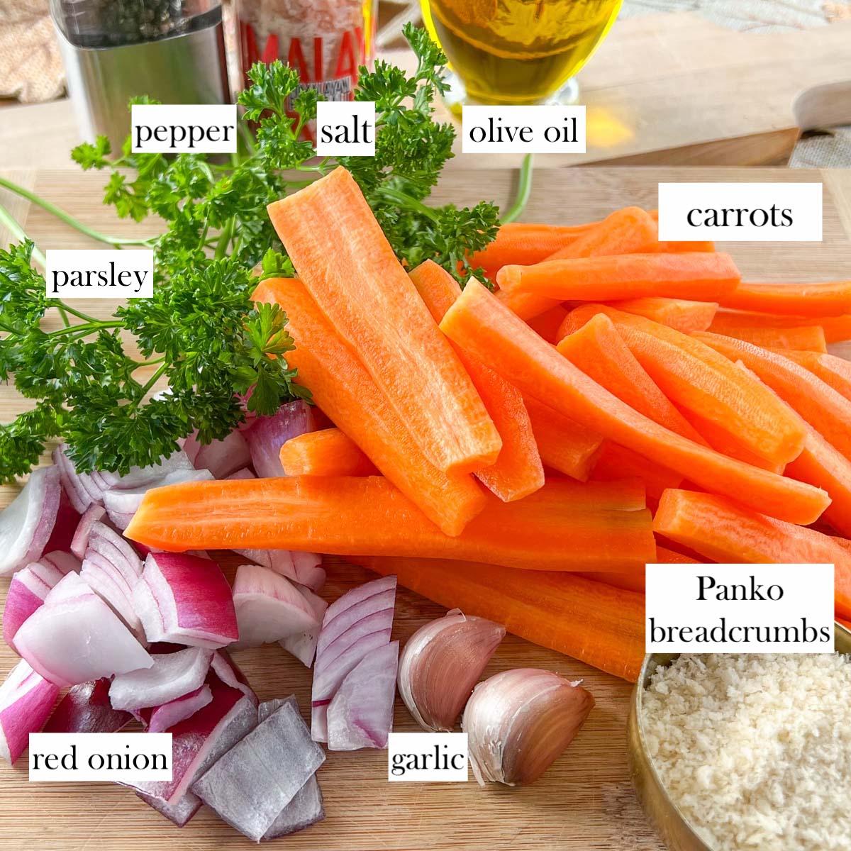 Sliced carrots and red onion, parsley, garlic and breadcrumbs on wood board.