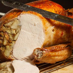 Roast turkey filled with stuffing being carved.
