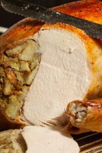 Roast turkey filled with stuffing being carved.